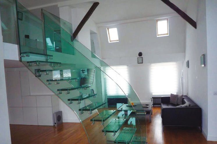 Escalera del vidrio flotante con cerramiento del mismo material. Los laterales proporcionan seguridad a la vez que mantienen la transparencia. Incorpora color sin interrumpir las visuales sino más bien colaborando con ellas.