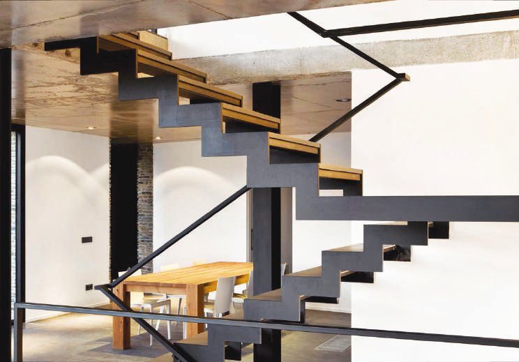 Escalera con estructura de metal y madera donde se imponen las líneas rectas. La calidez de la madera rompe la ortogonalidad de las formas.
