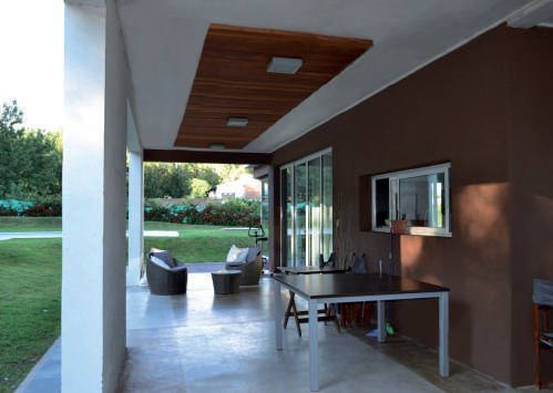 Galería, espacio con importante integración con los áreas verdes. Se destaca la aplicación de madera como cielorraso.