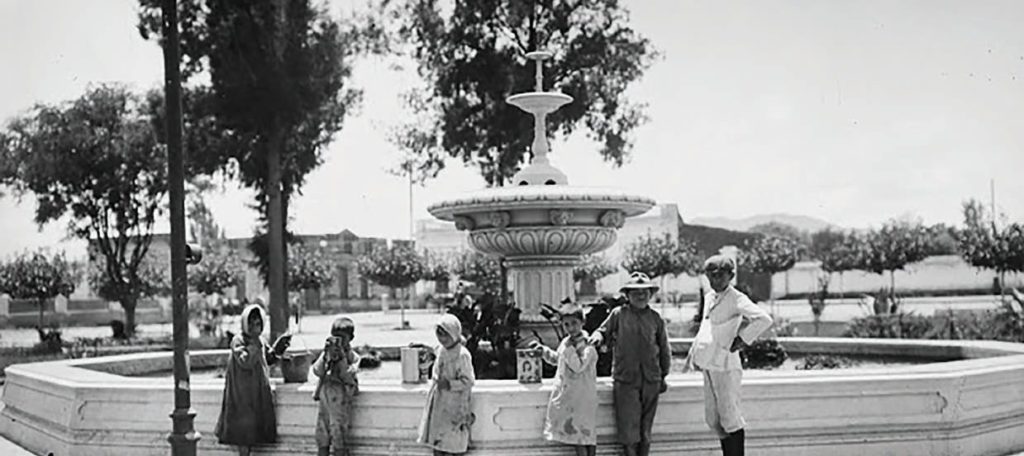 Un grupo de niños busca agua en la fuente de plaza Independencia, antes que la demolieran en 1914. (Archivo fotográfico La Vía)
